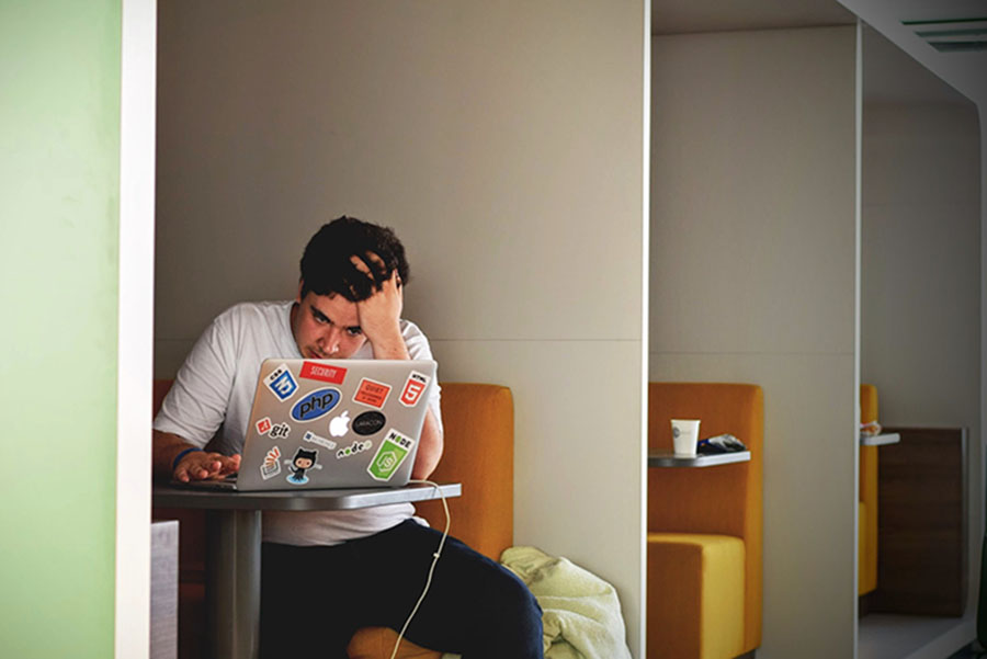 Student with head in hand on a laptop